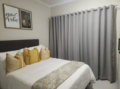 a bedroom with a large bed with gray curtains at 93 on new unique and classy in Midrand