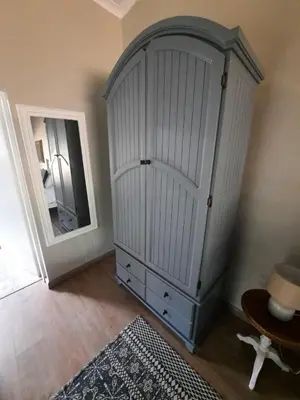 a large white cabinet in a room with a mirror at Nel's Cottage, a private and peaceful cottage in Benoni