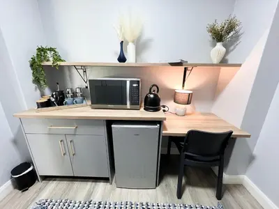 a desk with a microwave and a computer on it at Afrique134 Willow Tree Private Garden Suite in Pretoria