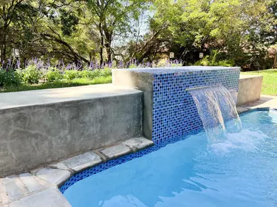 a pool with a water fountain in a yard at Afrique134 Willow Tree Private Garden Suite in Pretoria