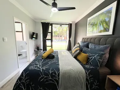 a bedroom with a bed and a ceiling fan at Afrique134 Willow Tree Private Garden Suite in Pretoria