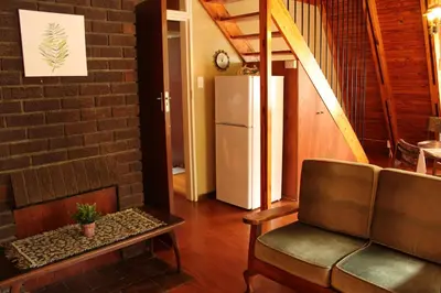 a living room with a couch and a refrigerator at Serenity Graskop, 3 bedroom A-Frame cottage in Graskop