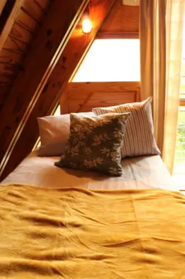 a bed in a room with a window at Serenity Graskop, 3 bedroom A-Frame cottage in Graskop