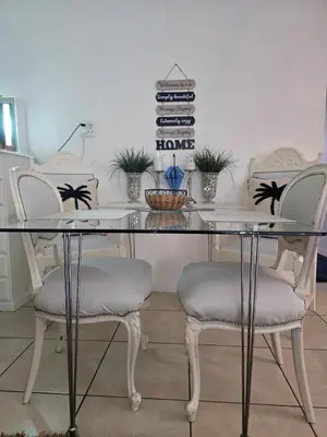 a glass table with two chairs and some plants at Ocean Vibe in Pretoria