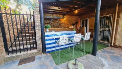 a patio with a blue bench and two chairs at Ocean Vibe in Pretoria