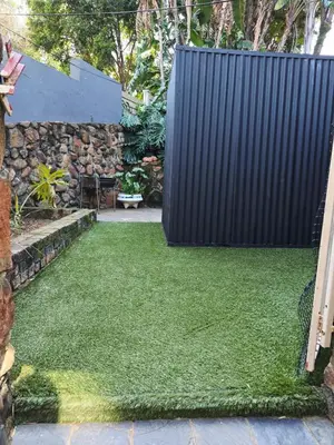 a garden with a black fence and green grass at Ocean Vibe in Pretoria