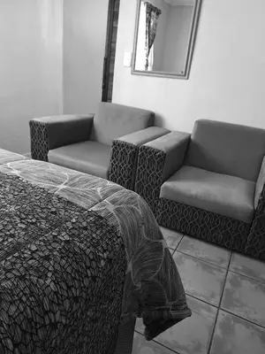a bedroom with a bed and a couch and a mirror at Residential Inn in Pretoria