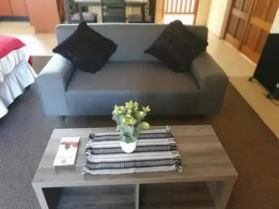 a living room with a couch and a table with towels at Roosthaven Guesthouse in Centurion