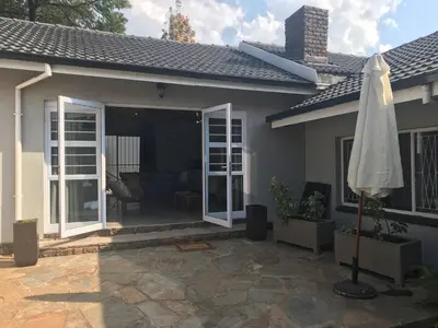 a house with a patio and an umbrella at Blue Lotus Guest House Pta East-Solar power in Pretoria