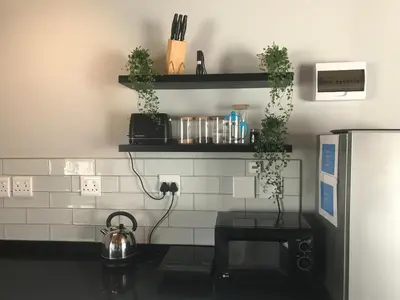 a kitchen with black and white tiles on the wall at Blue Lotus Guest House Pta East-Solar power in Pretoria