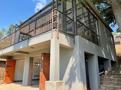 a building with a balcony and a staircase at Sun Room (Studio) on the edge of the Harties dam. in Hartbeespoort