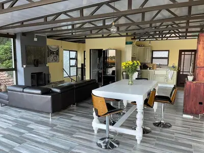 a living room with a white table and chairs at Sun Room (Studio) on the edge of the Harties dam. in Hartbeespoort