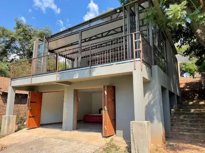 a building with a balcony with a staircase at Sun Room (Studio) on the edge of the Harties dam. in Hartbeespoort
