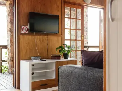 a living room with a tv on a wall at Stone cottage in Haarties in Kalkheuvel