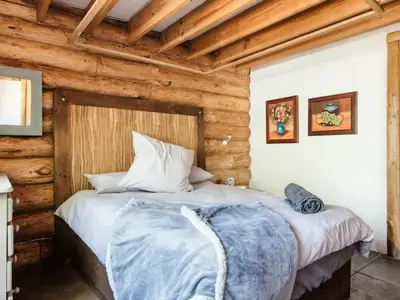 a bedroom with a bed in a log cabin at Stone cottage in Haarties in Kalkheuvel