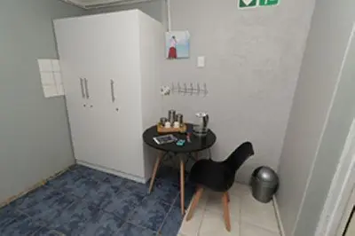 a room with a small table and a black chair at Quintax Guest House in Pretoria