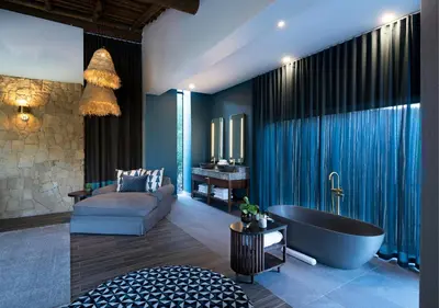 a bathroom with a tub and a couch and a sink at Babohi at Qwabi Private Game Reserve by NEWMARK in Bela-Bela