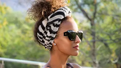 a woman wearing a head scarf and sunglasses at Babohi at Qwabi Private Game Reserve by NEWMARK in Bela-Bela