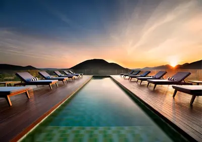 a pool with lounge chairs on the deck of a hotel at Babohi at Qwabi Private Game Reserve by NEWMARK in Bela-Bela