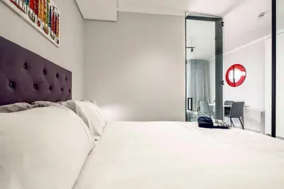 a bedroom with a large white bed and a mirror at Keza Cove at Waterfall Ellipse in Midrand