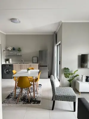 a kitchen and dining room with a table and chairs at Blue Lilly - 50 on Lever Unit 19 in Midrand