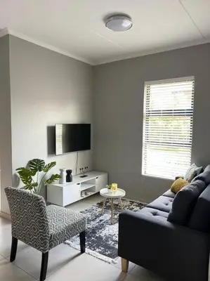 a living room with a couch and a chair at Blue Lilly - 50 on Lever Unit 19 in Midrand