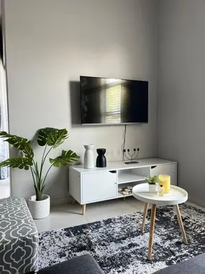 a living room with a tv and a table at Blue Lilly - 50 on Lever Unit 19 in Midrand