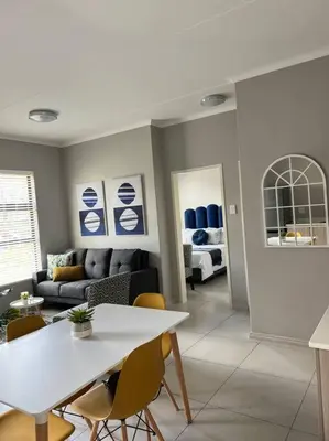 a living room with a white table and chairs at Blue Lilly - 50 on Lever Unit 19 in Midrand